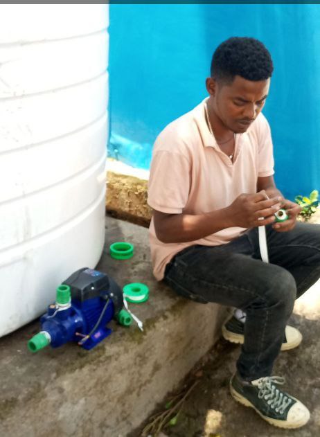 Technician wrapping fittings for a water-pump install